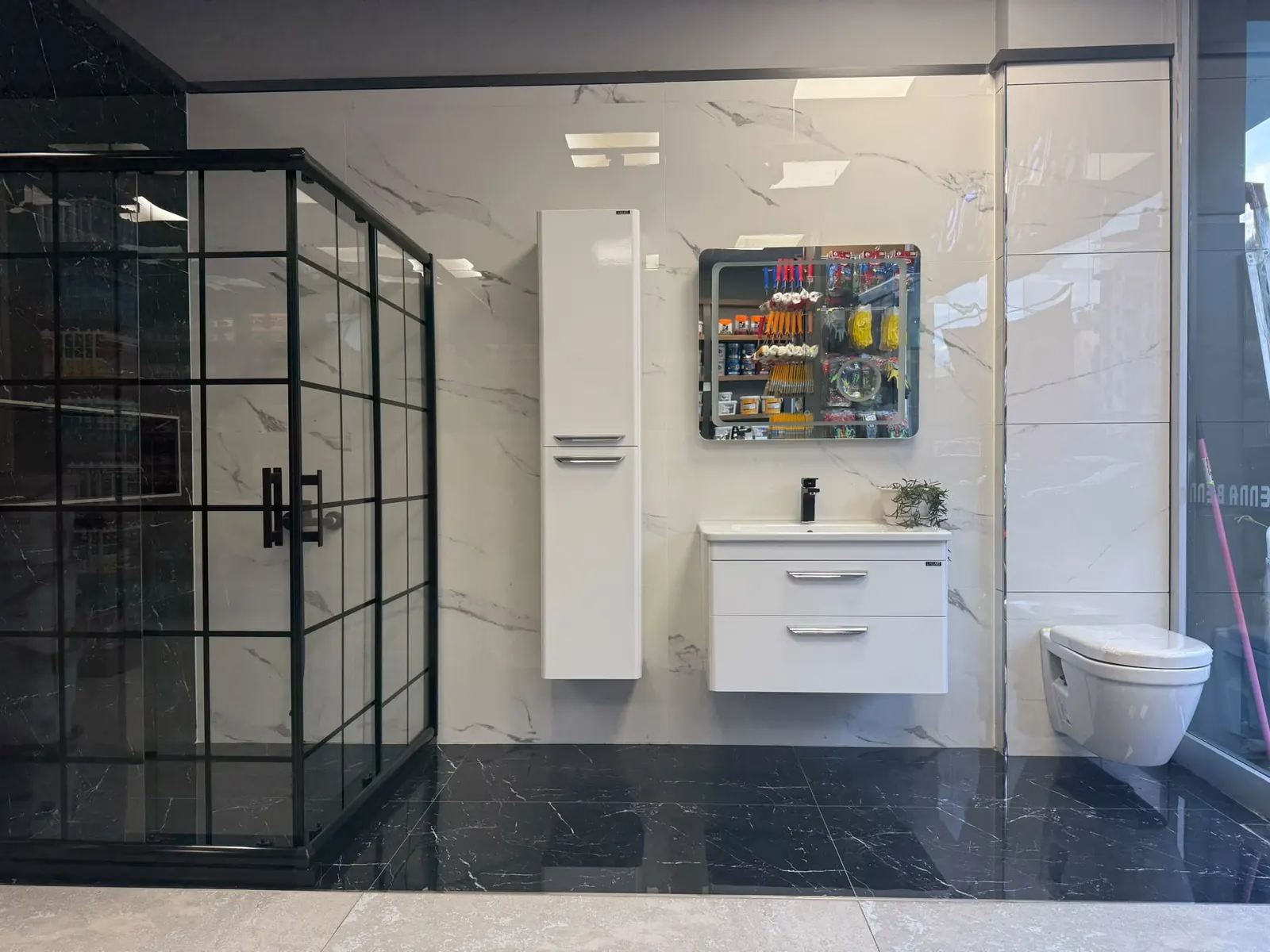 Siyah kafesli duşakabin, boy dolabı ve asma klozetli banyo